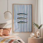 a bedroom with a bed, a framed picture of three fish, and a pendant light hanging above the bed.