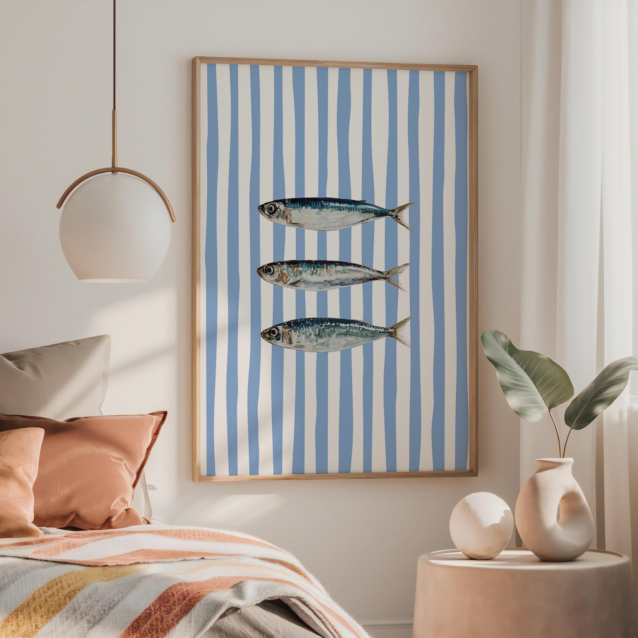 a bedroom with a bed, a framed picture of three fish, and a pendant light hanging above the bed.