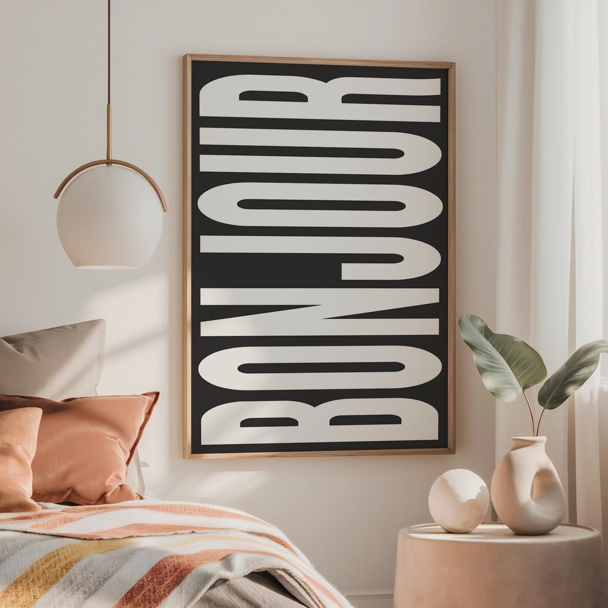 a bedroom with a large framed poster of the word " bonjour" hanging on the wall, a bed with colorful pillows, and a small side table with a vase and plant.