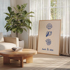 a cozy living room with a large potted plant, a wooden coffee table, and a framed poster featuring illustrations of seashells and a sun.