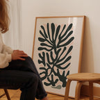 A person is sitting in a chair in front of a large abstract art print on a wall.
