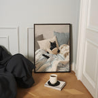 A framed painting of a black cat lying on a bed, with a cup of coffee and a book on the floor in front of it.
