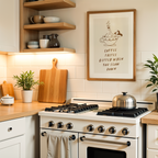 a cozy kitchen scene with a white gas range, wooden cutting board, and various kitchen accessories such as a coffee maker and a potted plant. Above the range, there is a framed quote that reads "Coffee tastes better when you slow down".