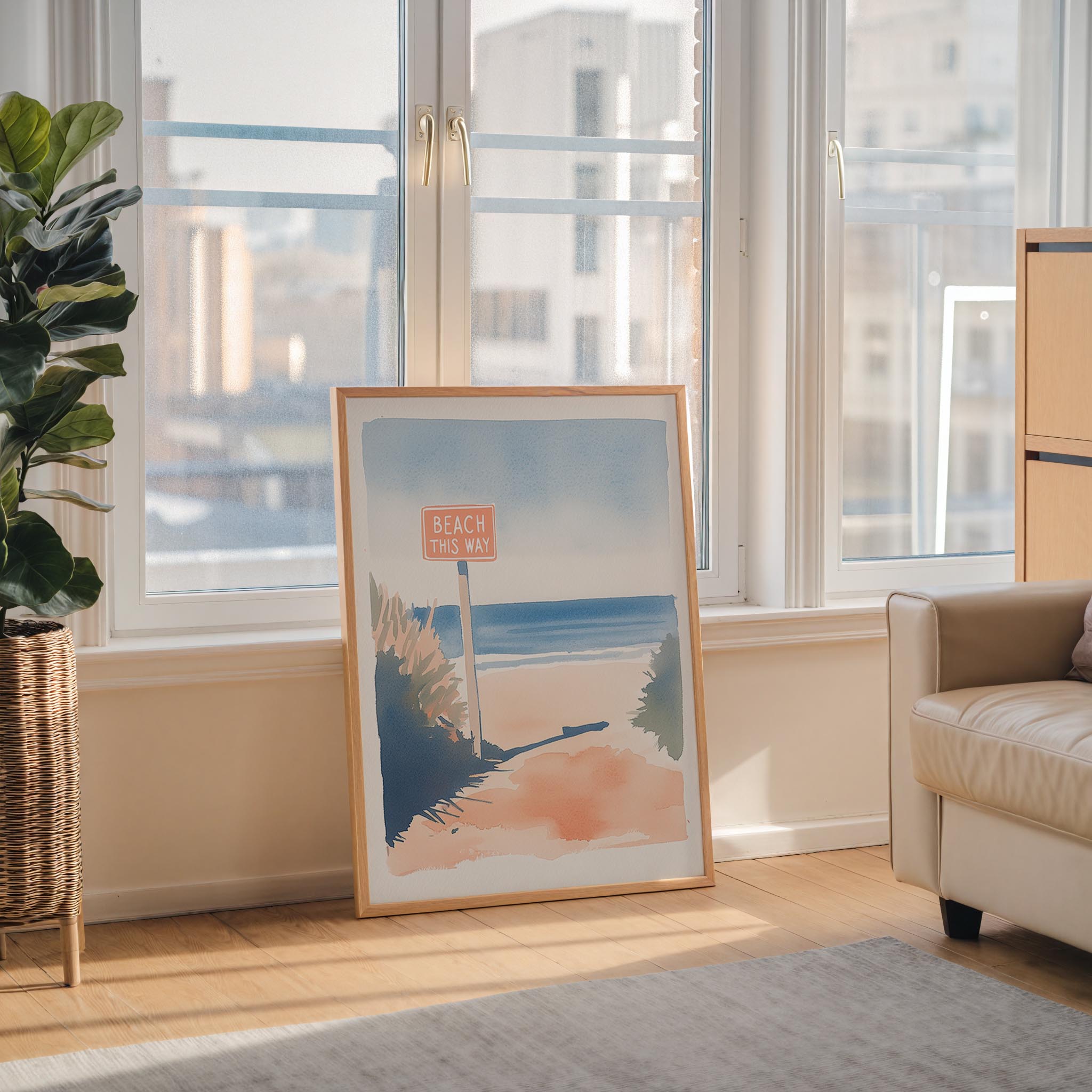 a large framed painting of a beach scene with a sign that says "Beach this way" in the foreground.