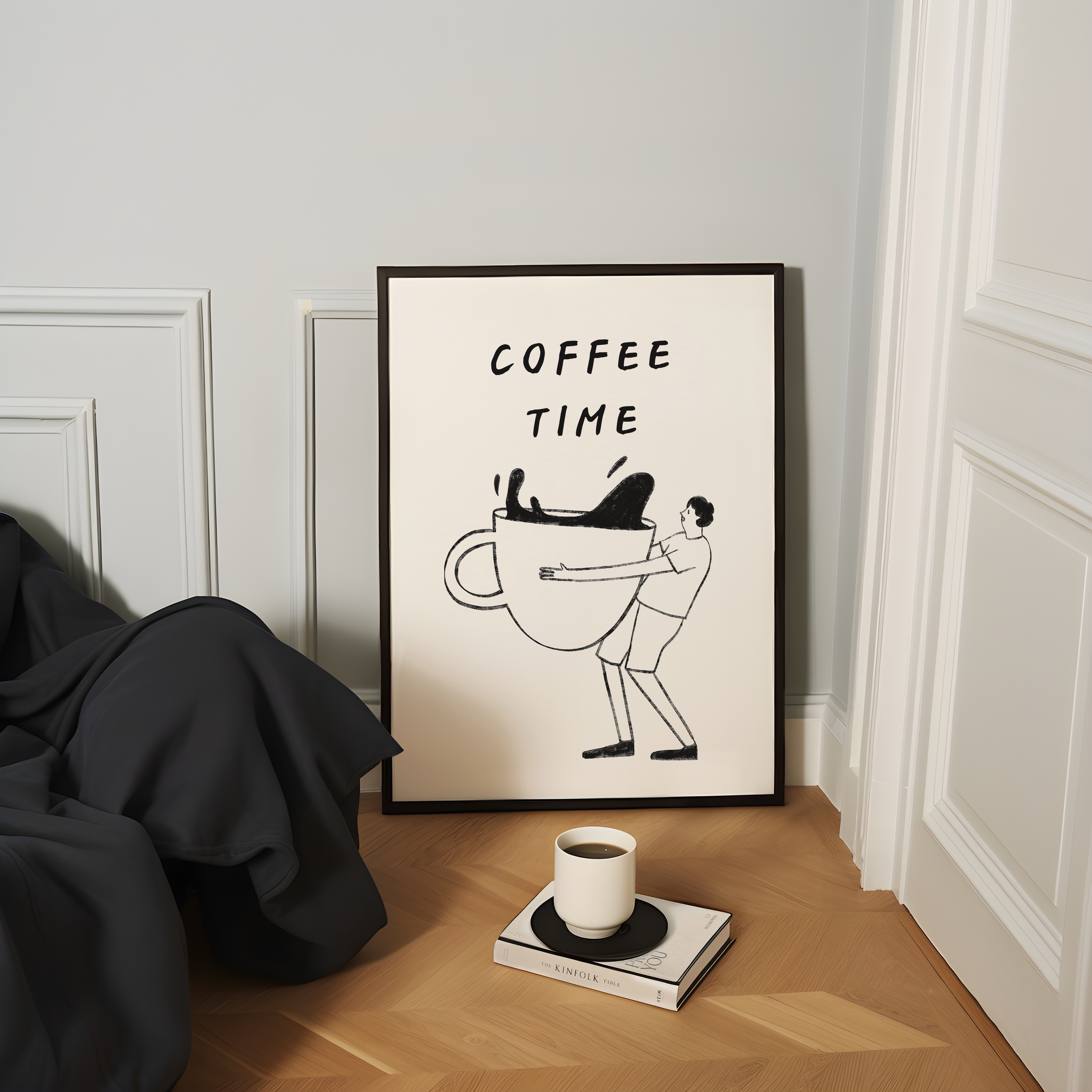 a framed poster with a cartoon illustration of a man holding a large coffee mug, accompanied by the text "COFFEE TIME". The poster is displayed on a wall, with a book and a cup of coffee placed on a surface in front of it.