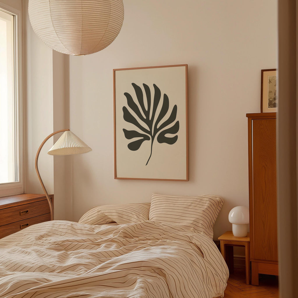 a bedroom with a bed, a lamp, and a framed artwork on the wall.
