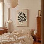 a bedroom with a bed, a lamp, and a framed artwork on the wall.