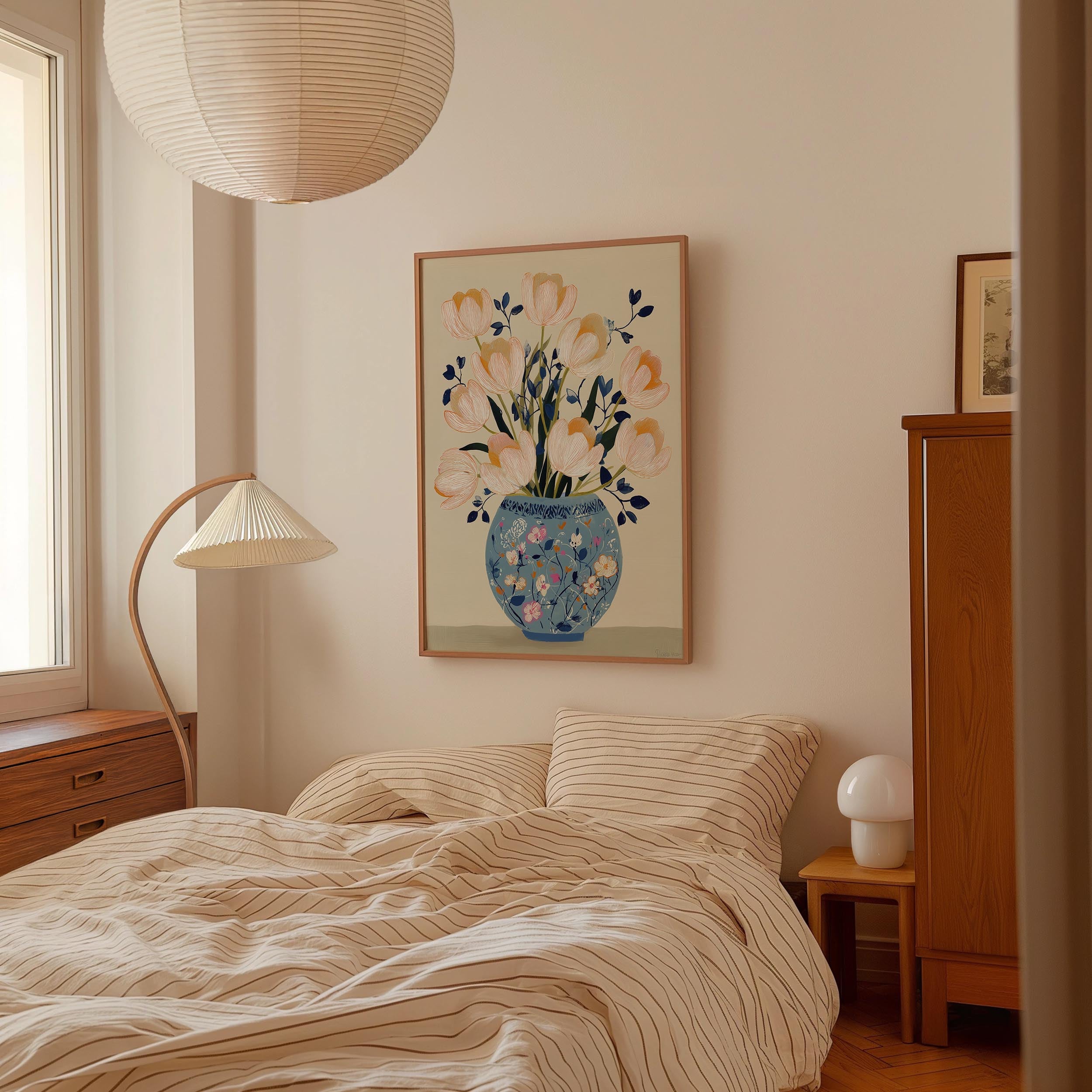 a cozy bedroom with a large bed, a wooden dresser, and a lamp. A framed painting of a vase with flowers is hanging on the wall above the bed.