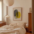 a cozy bedroom with a large bed, a wooden dresser, and a lamp. The room has a minimalist and modern design, with a large abstract painting hanging on the wall above the bed.