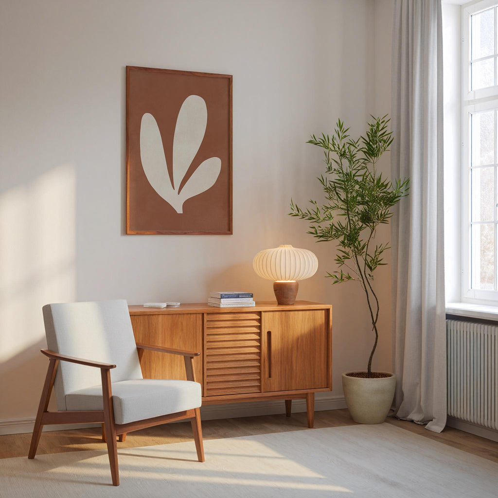 a cozy living room with a white armchair, a wooden sideboard, a lamp, and a potted plant. The room has a minimalist and modern design, with a large window providing natural light.