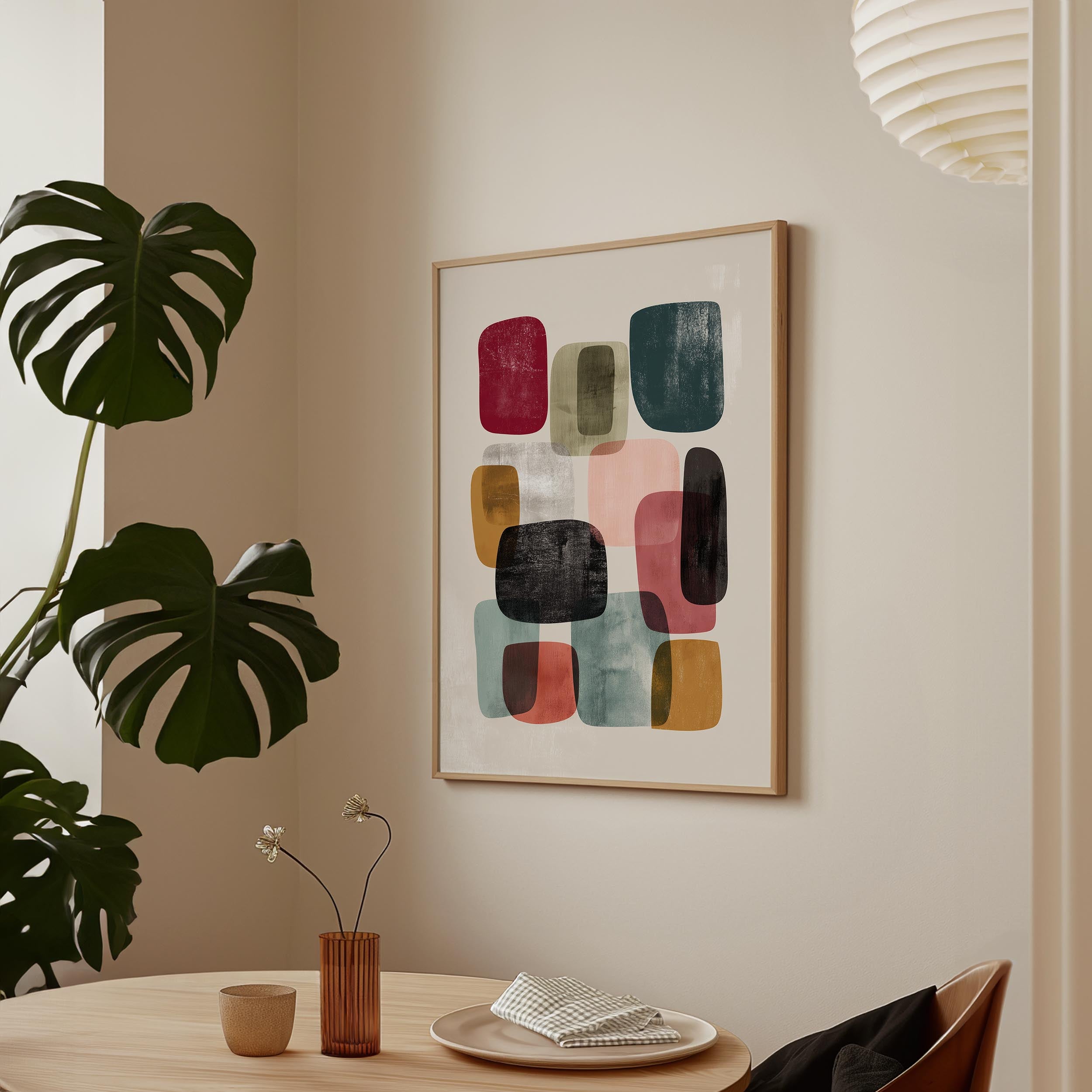 a modern art print hanging on a wall, with a wooden table and chairs in the foreground. The table has a vase with flowers and a cup, creating a cozy and inviting atmosphere.
