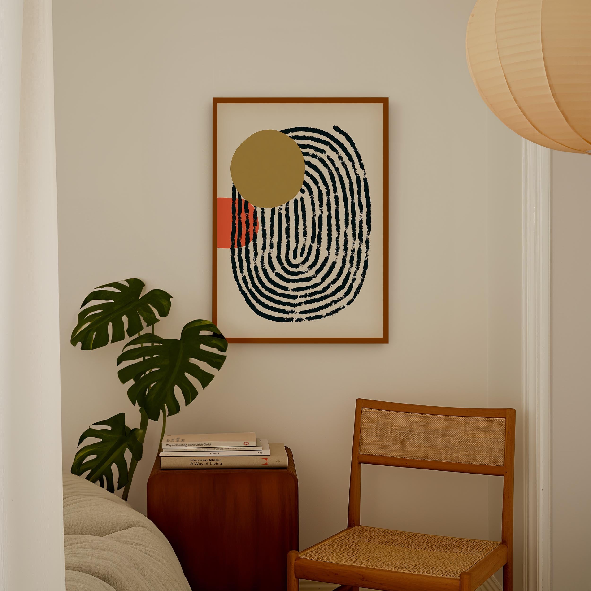 a minimalist living space with a framed abstract artwork hanging on the wall, a wooden chair, a stack of books, and a potted plant.