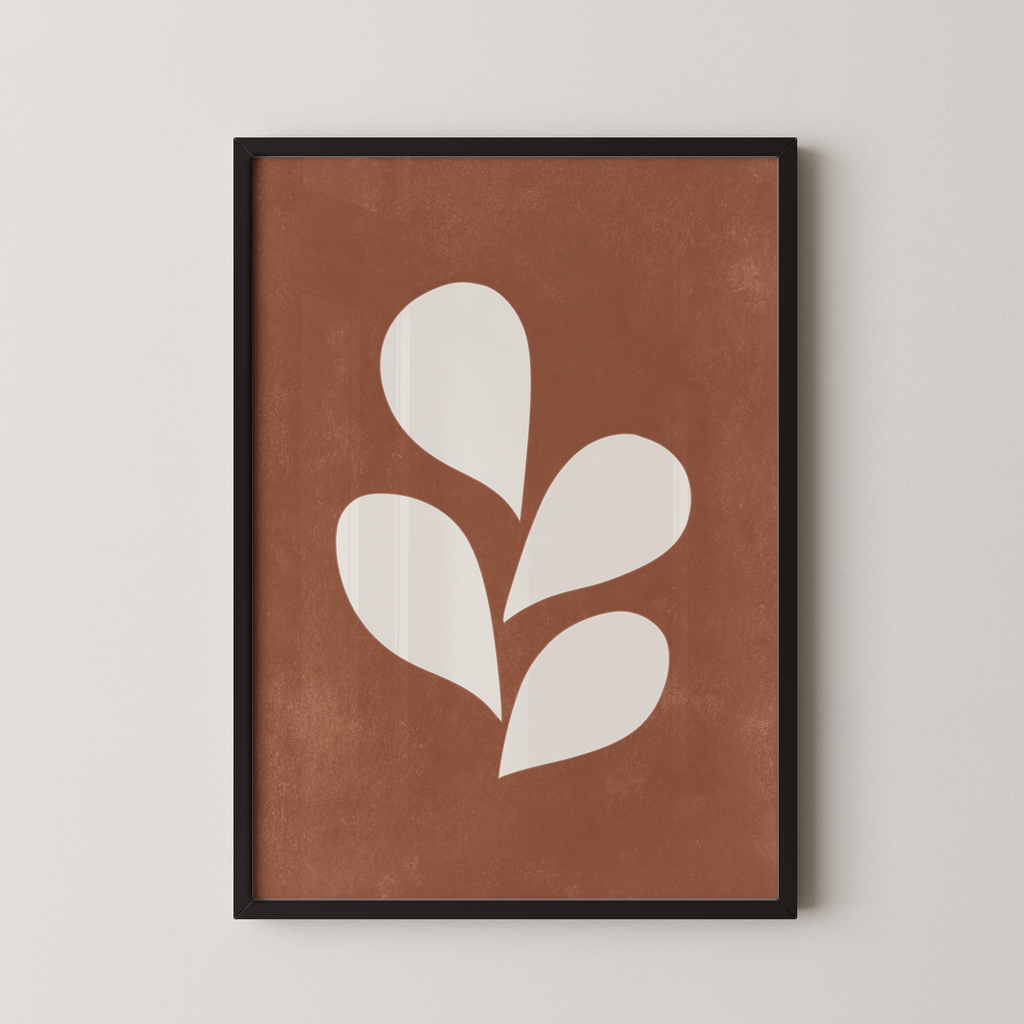 a framed print with a brown background and white leaf-like shapes.