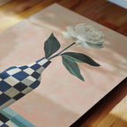 A white flower in a blue and white checkered vase is the central focus of the image.