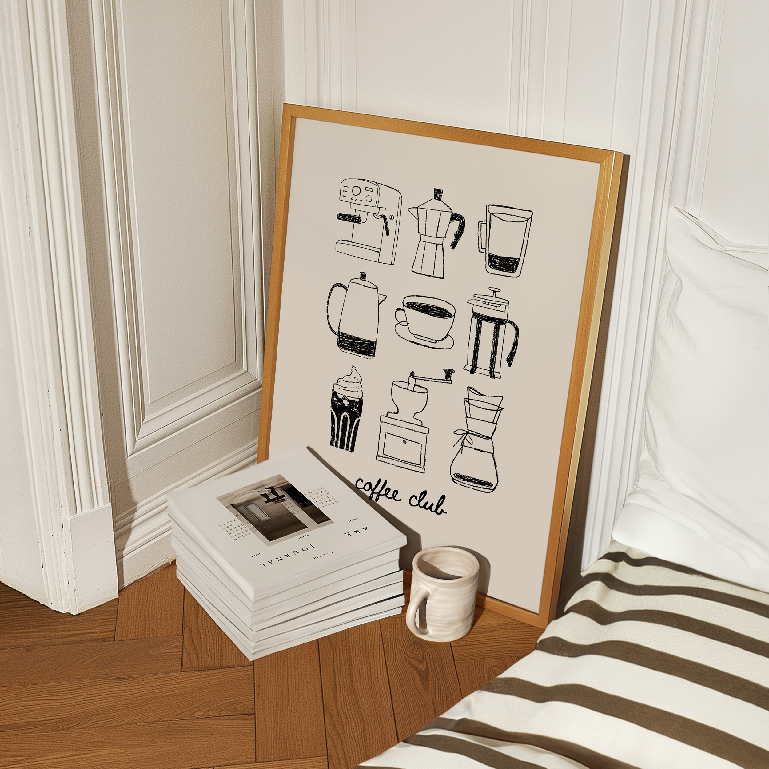 a framed poster of coffee-related illustrations, a stack of books, and a coffee mug on a wooden floor.