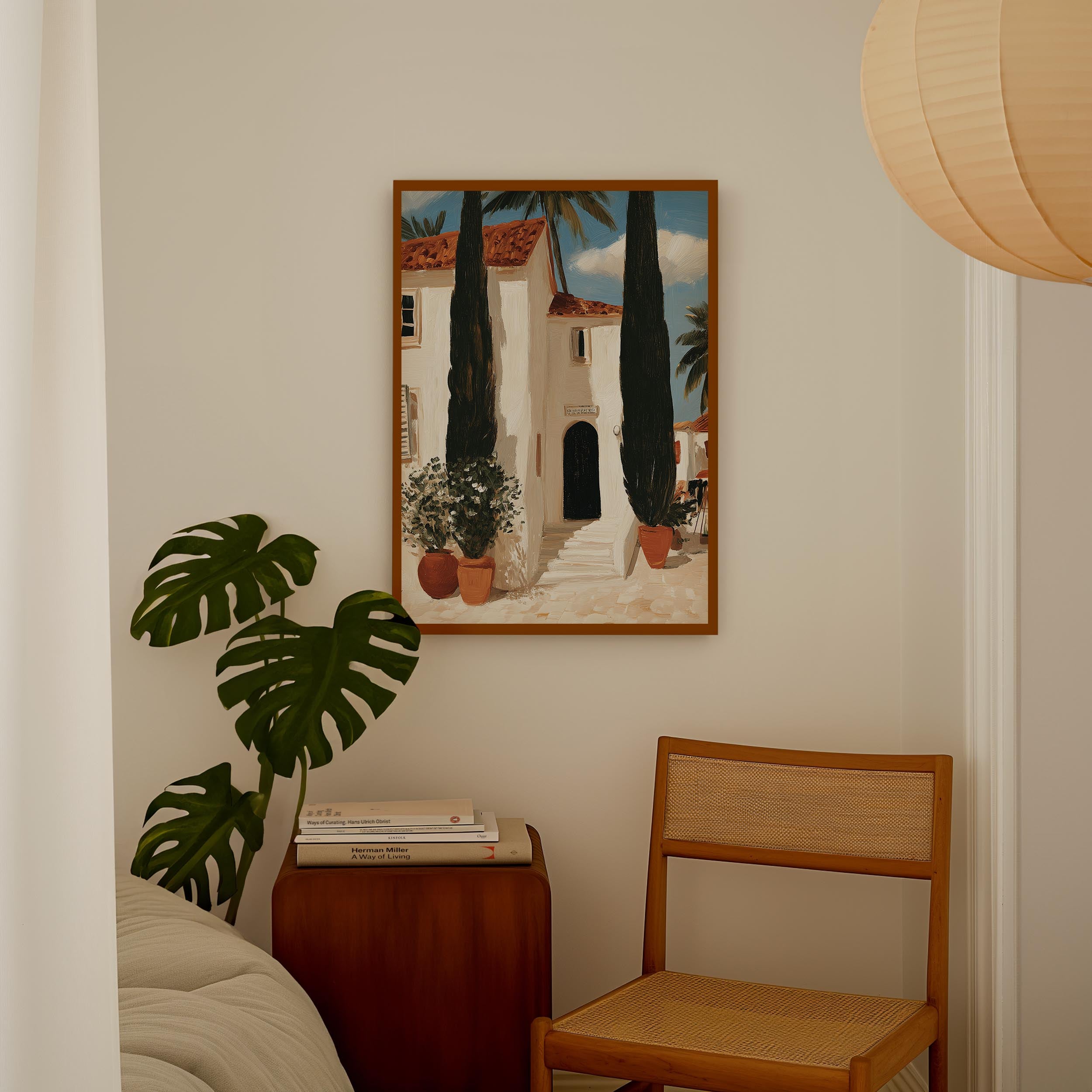 a cozy corner of a room with a painting of a house, a potted plant, and a wooden chair.