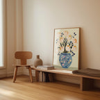 a wooden chair, a wooden bench, a vase with flowers, and a framed picture of flowers on a wall.