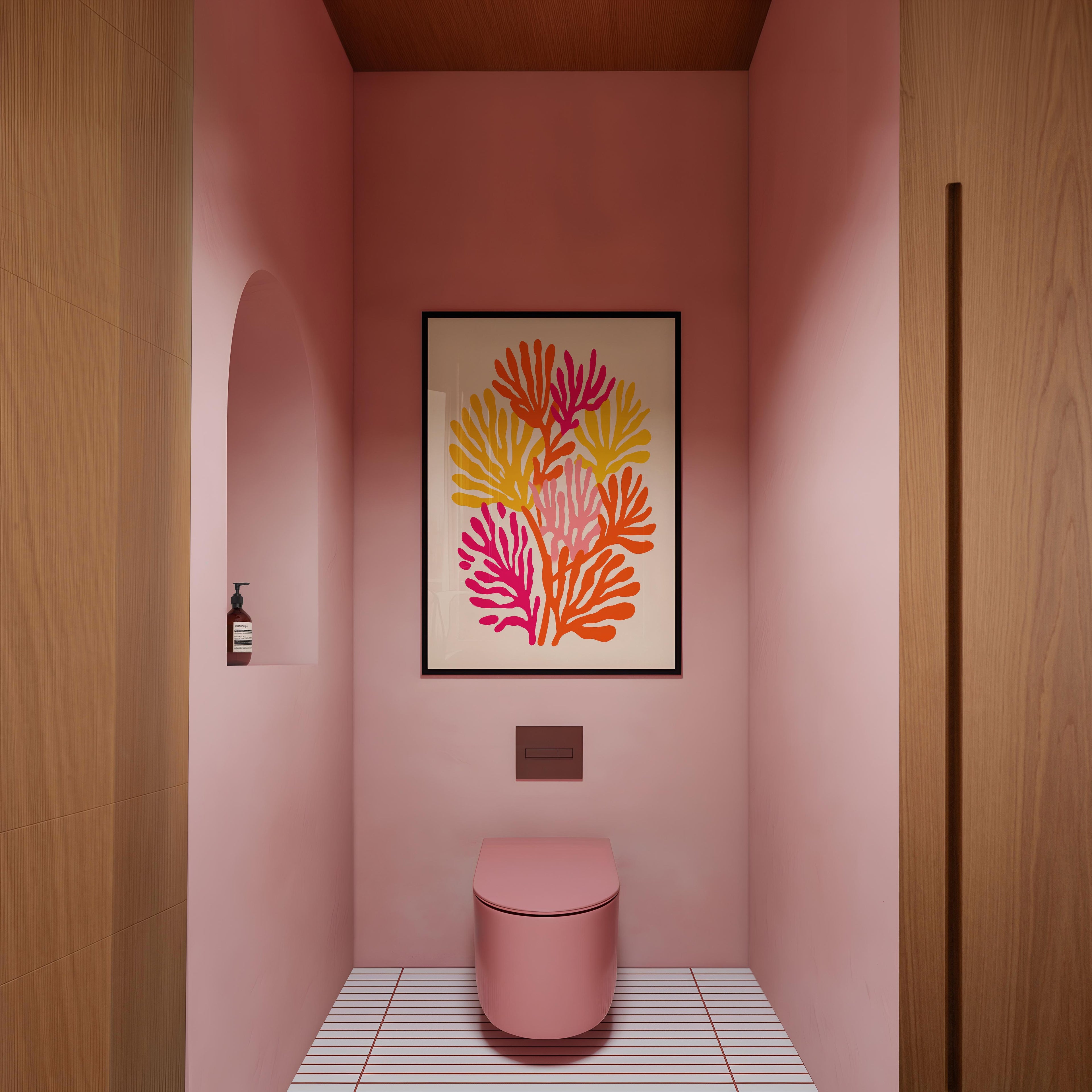 a bathroom with a pink toilet and a framed artwork featuring a floral design on the wall.