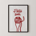 a framed poster with a red illustration of a fork and a piece of spaghetti, accompanied by the text "Pasta lover" written in a stylized font.