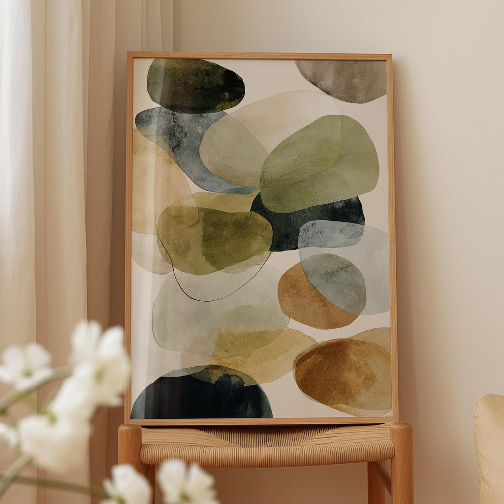 a wooden chair with a framed abstract painting hanging on it, placed in front of a window with white curtains.