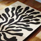a close-up view of a piece of paper with a striking black and white abstract design resembling a stylized tree or plant.