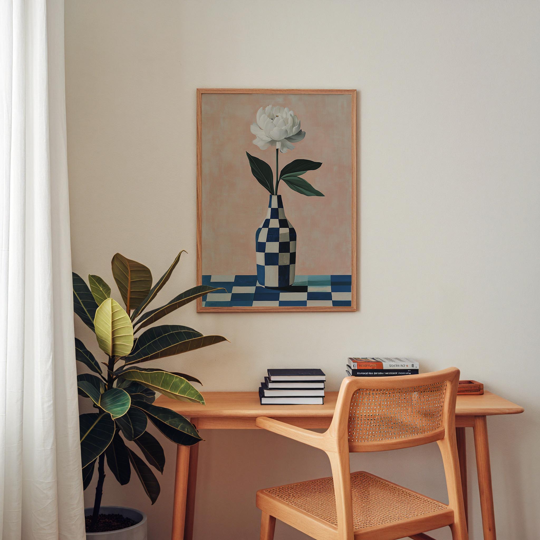 a wooden desk with a stack of books on it, a potted plant, and a framed painting of a flower on the wall above the desk.