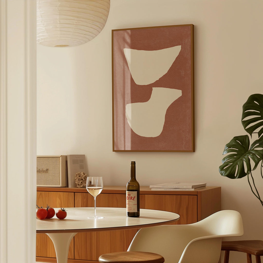 a dining room with a table set for two, a bottle of wine, and a framed abstract art piece on the wall.