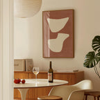 a dining room with a table set for two, a bottle of wine, and a framed abstract art piece on the wall.