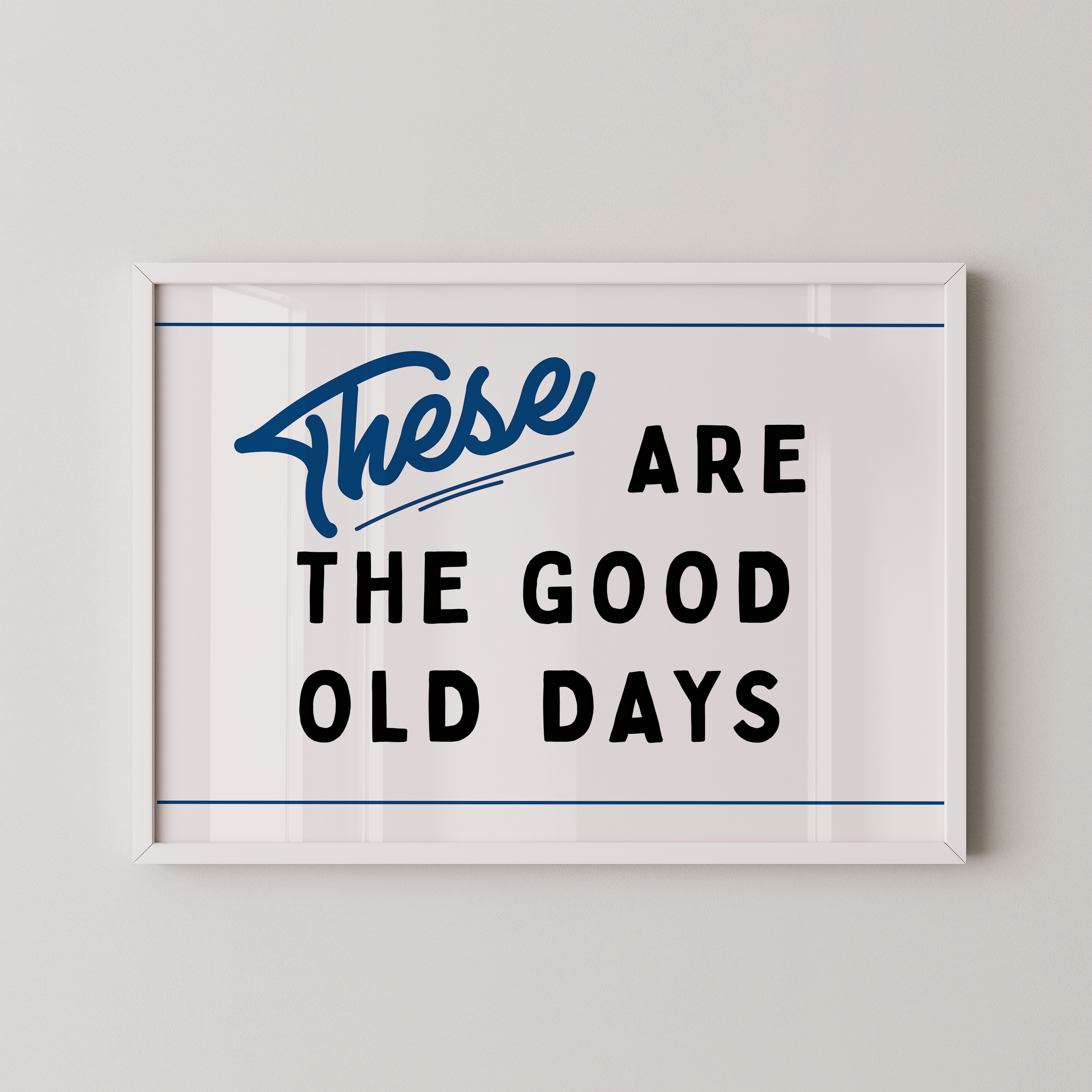 a framed poster with the text "These are the good old days" in a blue cursive font.
