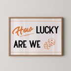 a framed poster with the text "How LUCKY ARE WE" and two dice graphics.