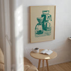 a cozy corner of a room with a wooden table, a white coffee cup, and an open book, all set against a backdrop of a framed illustration of a coffee maker.