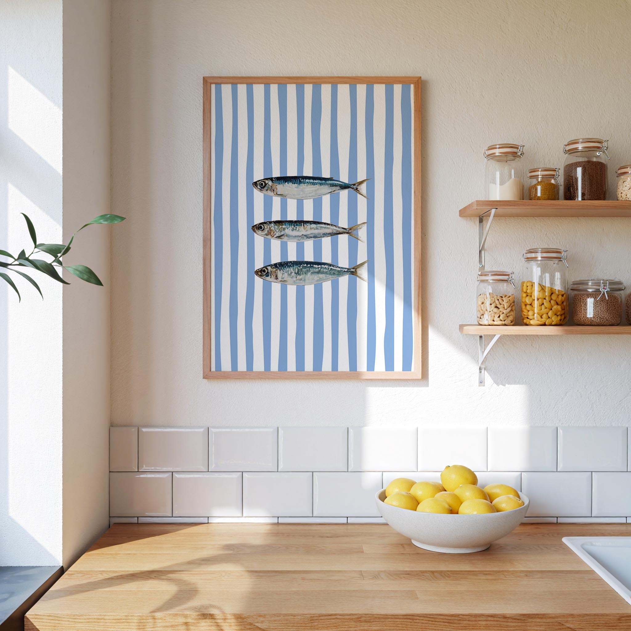 a kitchen counter with a bowl of lemons, a framed picture of three fish, and shelves with various jars and containers.