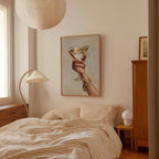 a bedroom with a bed, a lamp, and a framed picture of a hand holding a glass of wine.