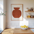 a kitchen counter with a bowl of lemons, a framed abstract artwork, and shelves displaying various jars and containers.