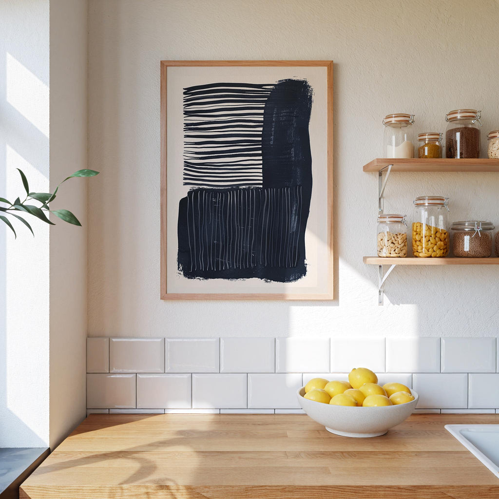 a kitchen counter with a bowl of lemons, a framed abstract art piece, and a shelf with various jars and containers.