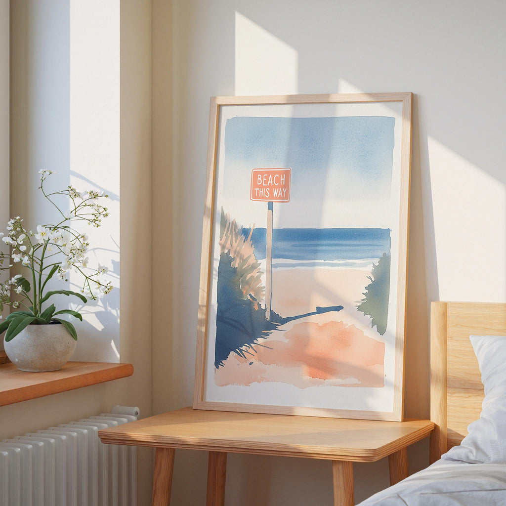 a framed painting of a beach scene with a sign that says "Beach this way" in the foreground.