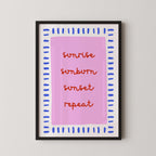 a framed poster with the text "sunrise, sunburn, sunset, repeat" written in a stylized font on a pink background.