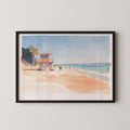 A framed watercolor painting depicting a beach scene with a lifeguard tower, people walking along the shore, and a clear blue sky.