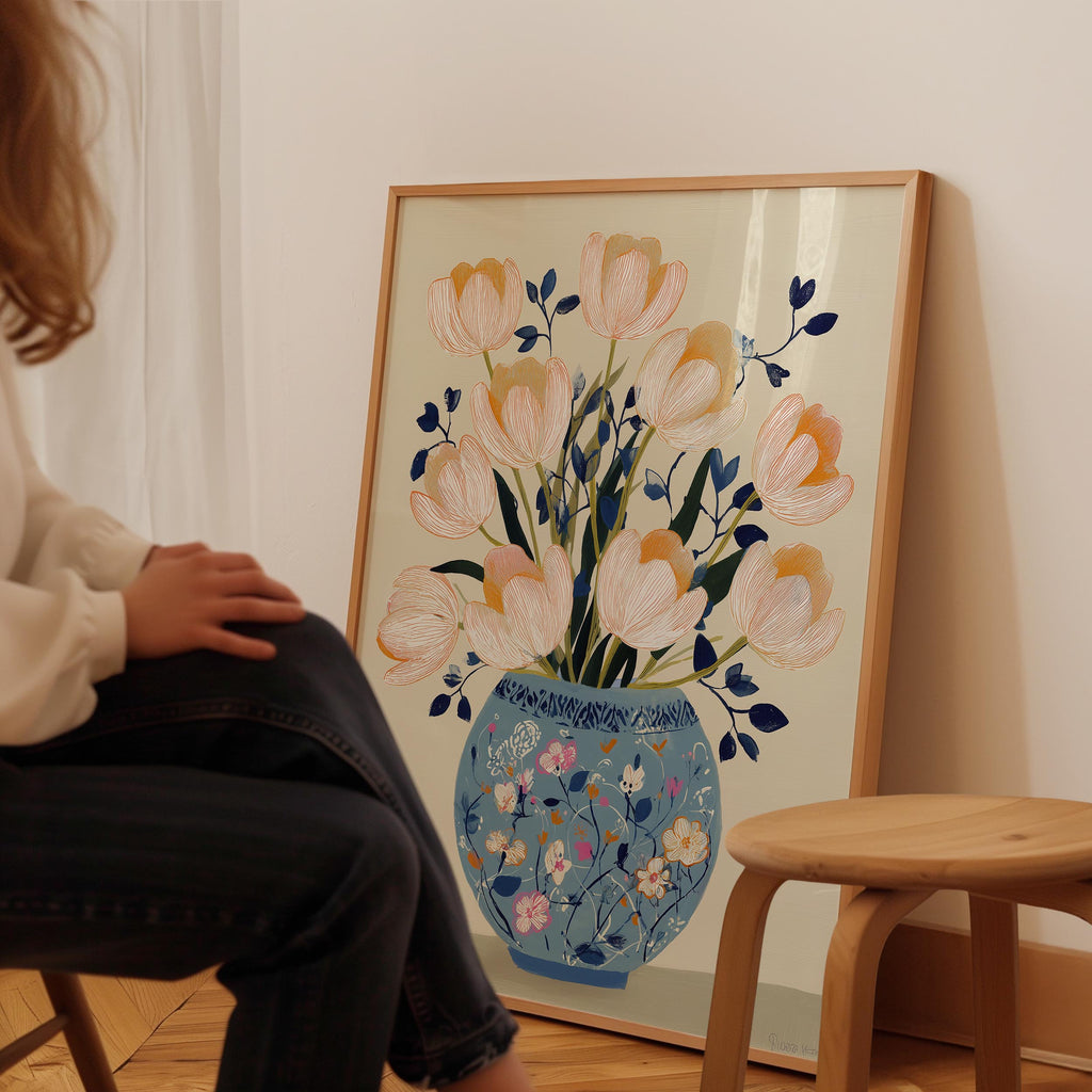 A person is sitting in front of a large framed painting depicting a vase with flowers.