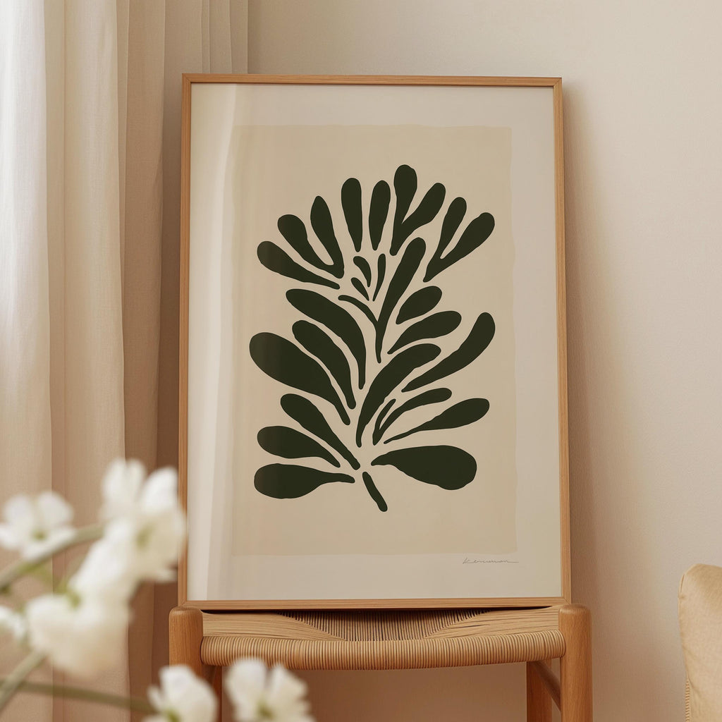 a framed artwork of a stylized plant or flower design, displayed on a wooden stand.