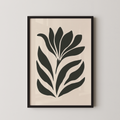 a framed artwork of a stylized plant or flower design in black and white.