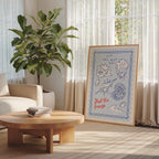 a living room with a large potted plant, a wooden coffee table, and a framed poster with a beach scene and the text "Feel the breeze".