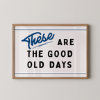 a framed poster with the text "These are the good old days" in a blue and black color scheme.