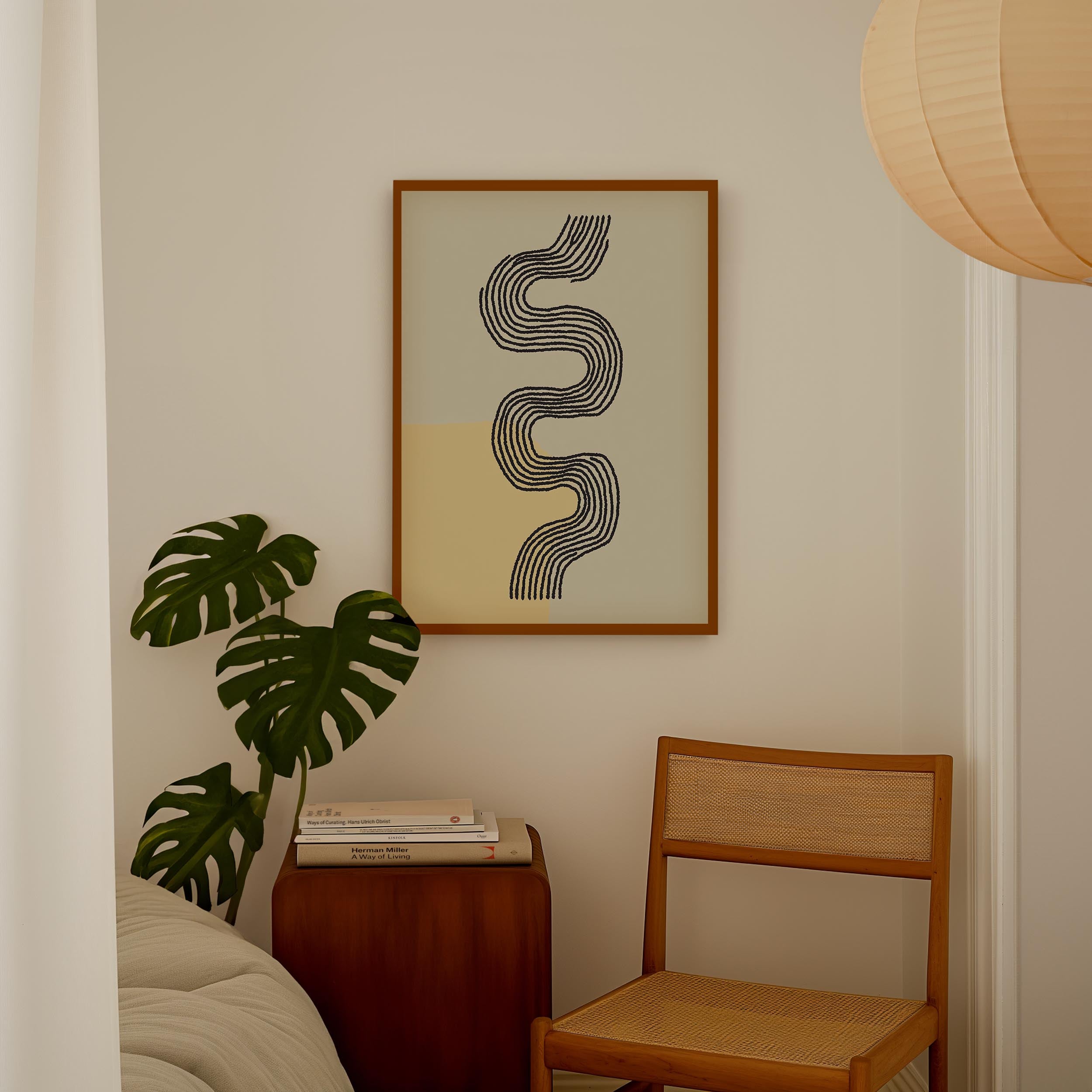 a cozy corner with a framed abstract artwork on the wall, a wooden chair, a small table with books, and a large monstera plant.