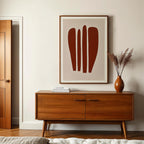a modern interior design with a wooden cabinet, a framed abstract artwork, and a vase with dried flowers on a table.