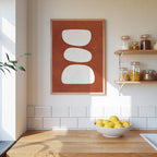a kitchen counter with a bowl of lemons, a framed abstract art piece, and shelves displaying various jars and containers.