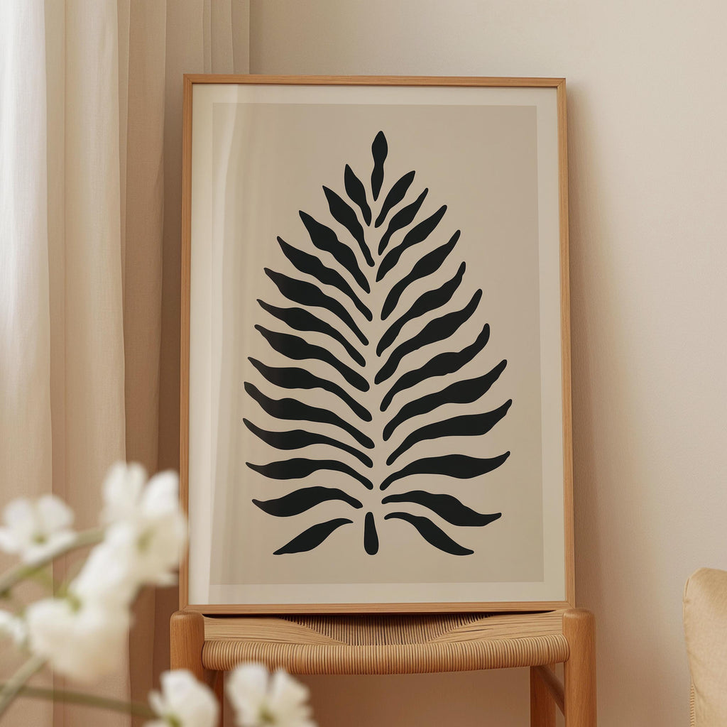 a framed artwork of a stylized leaf design in black and white.