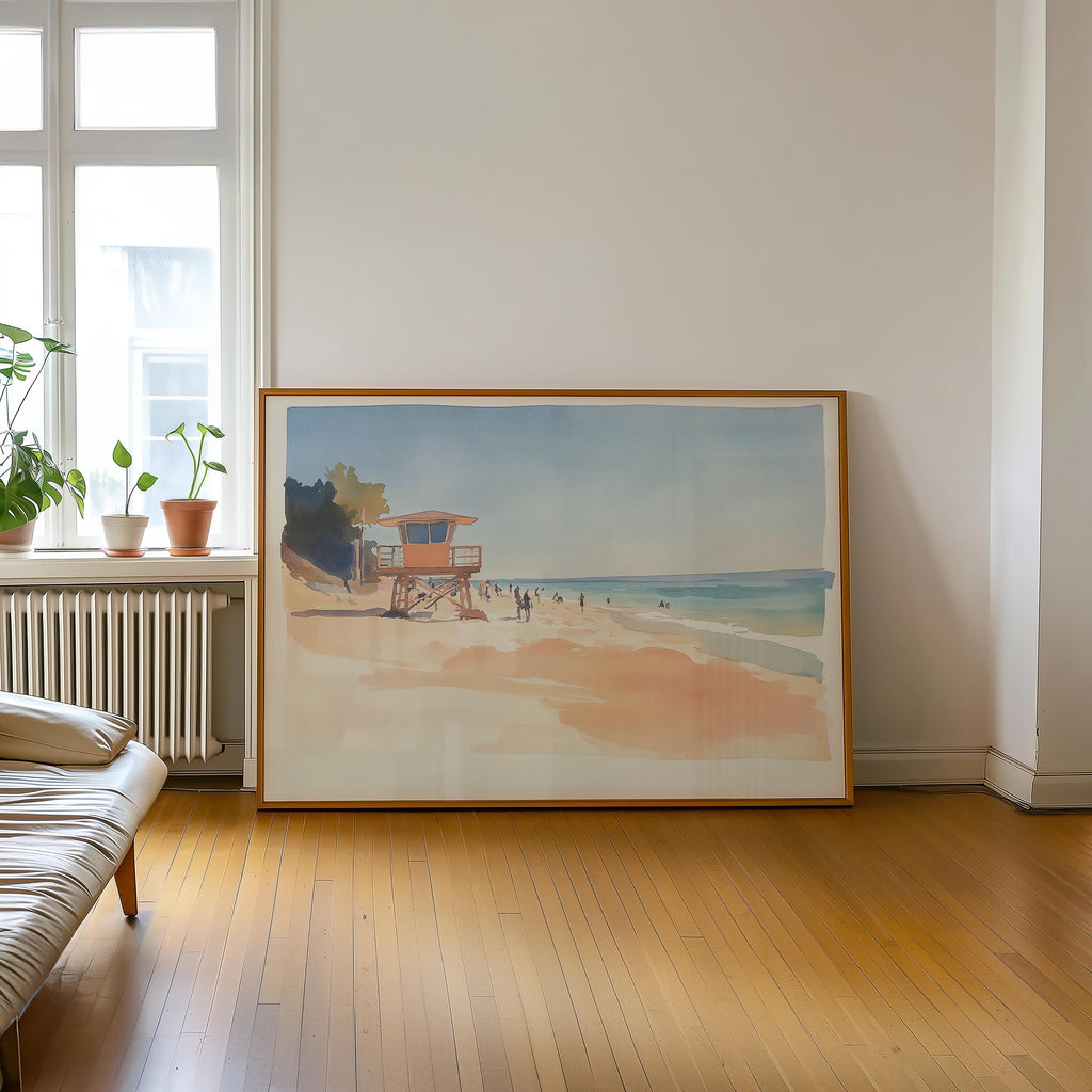 a large framed painting of a beach scene with a lifeguard tower, people, and a clear blue sky.