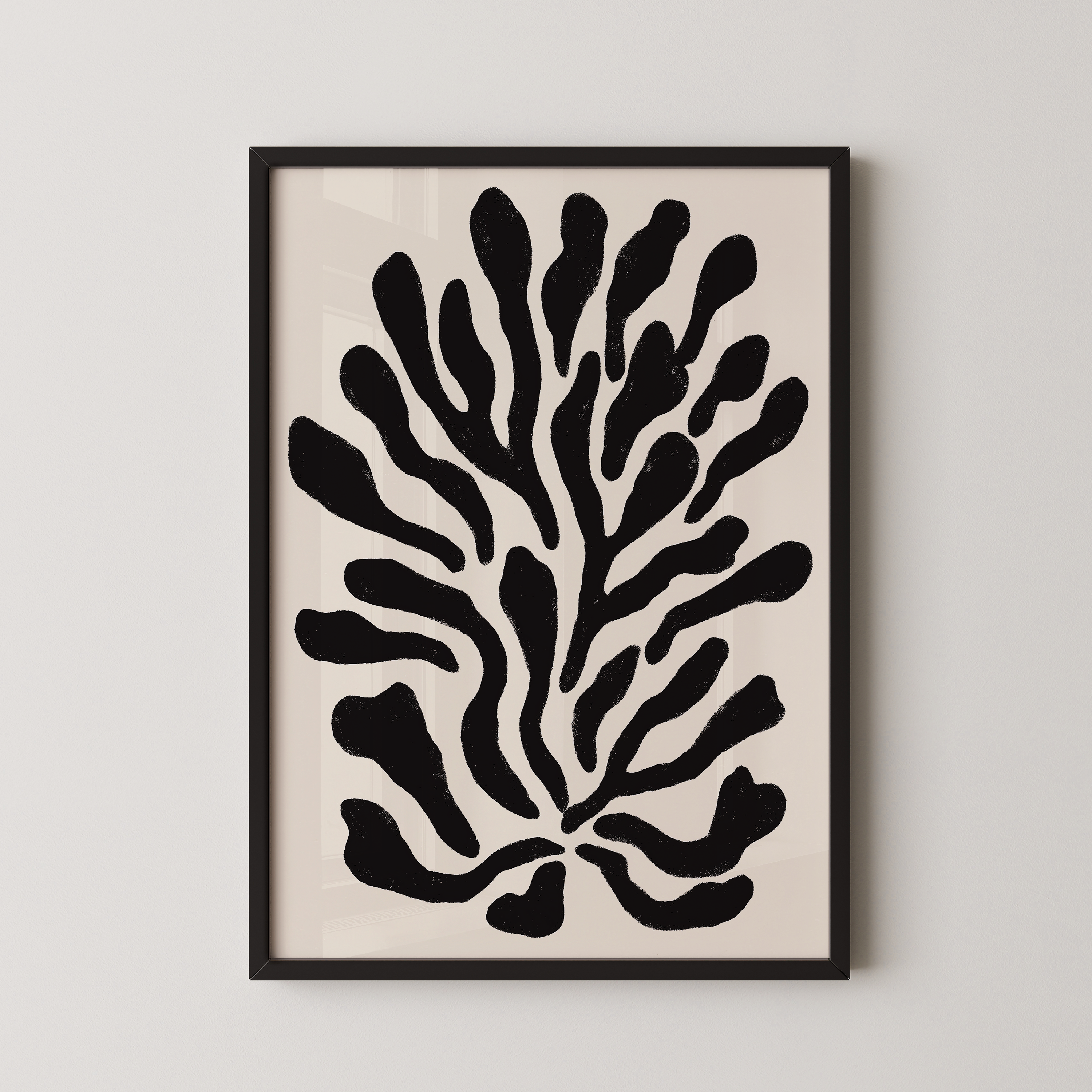 a framed abstract art piece with a black and white design of stylized shapes resembling a plant or tree.