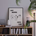a bookshelf with a framed poster that reads "Early Morning Coffee Club" above it. The poster also includes illustrations of a coffee maker, a bag of coffee beans, and a cup of coffee. The bookshelf is filled with various books, and there is a lamp and a plant in the background.
